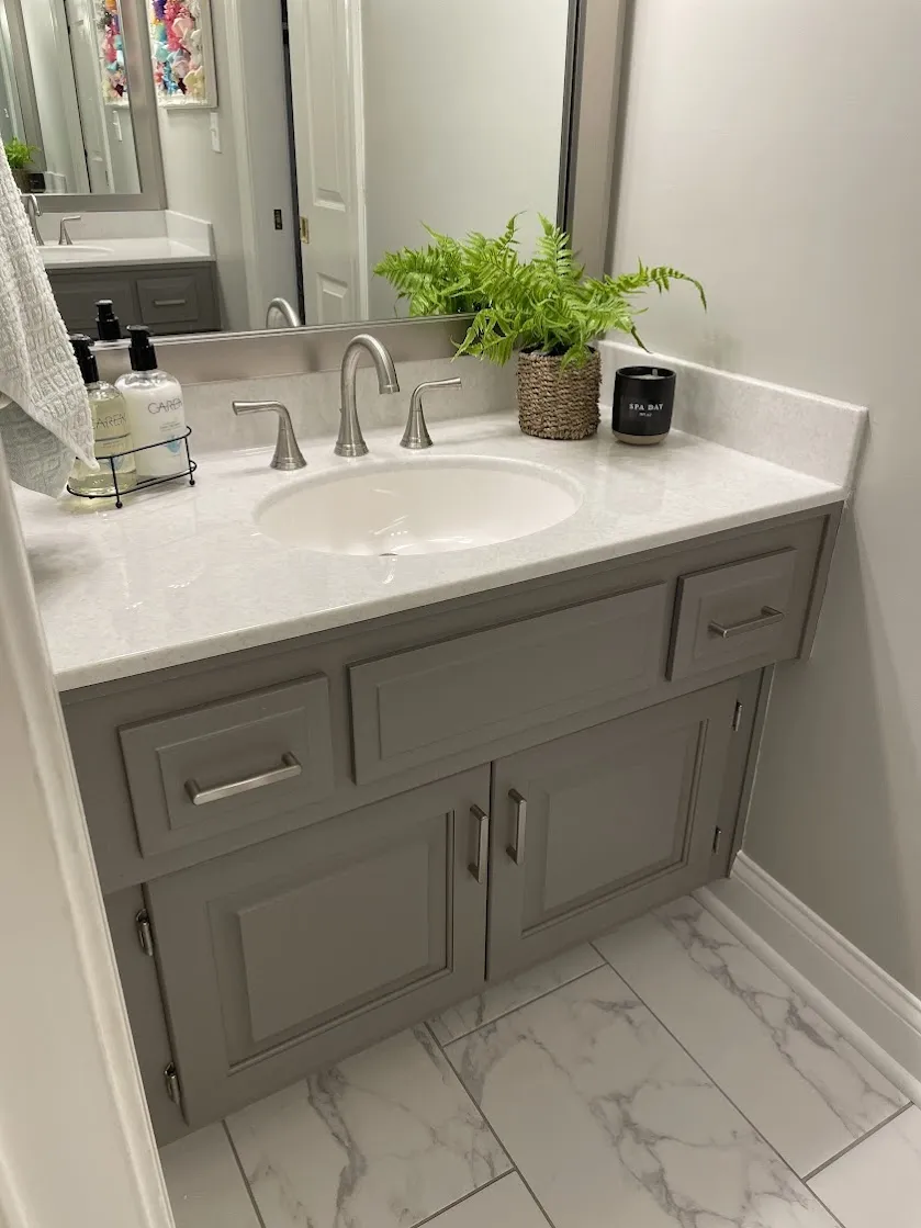 Gray vanity with a white solid-surface top and integral oval sink